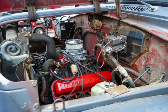 Inside the engine of an old truck with some new parts being installed.
